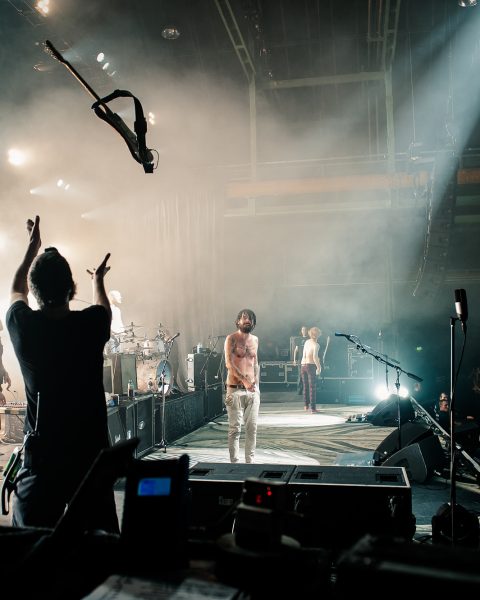 Simon Neil tosses guitar to Richard Pratt, Credit - Carla Mundy