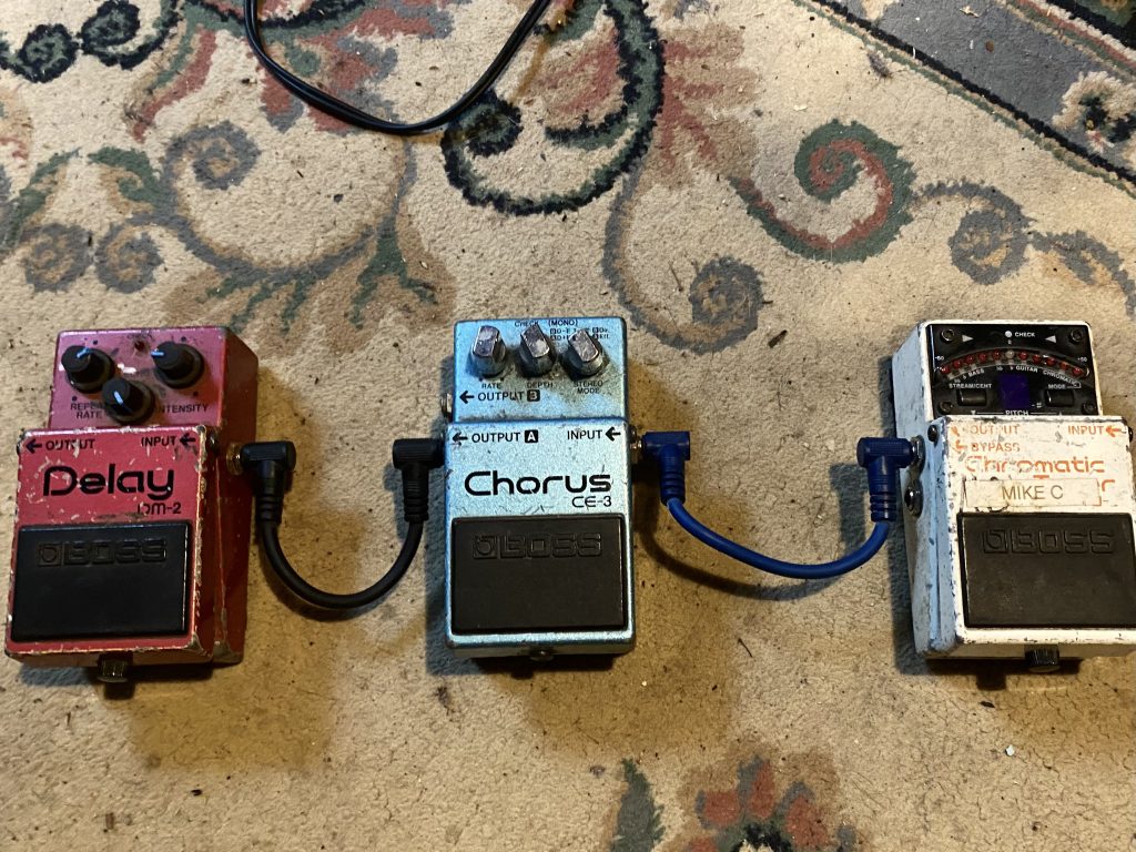 BOSS effects pedals including a CE-3 Chorus, DM-2 Delay, and TU-2 Chromatic Tuner.