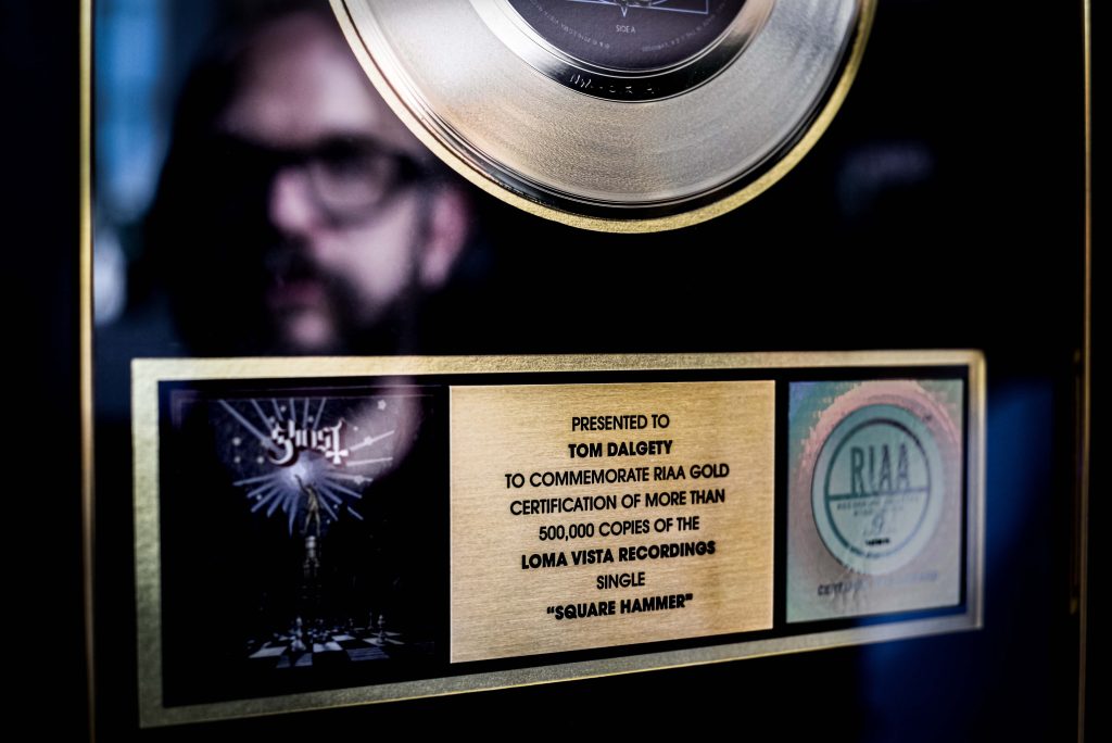 Producer Tom Dalgety's reflection in his gold disk commemorating 500,000 copies of the Ghost single "Square Hammer"