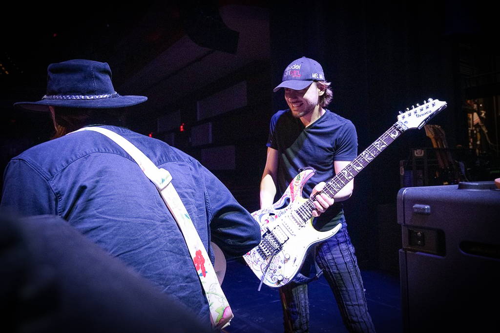 Steve Vai's guitar tech, Doug MacArthur, hands him a guitar during BEAT tour soundcheck