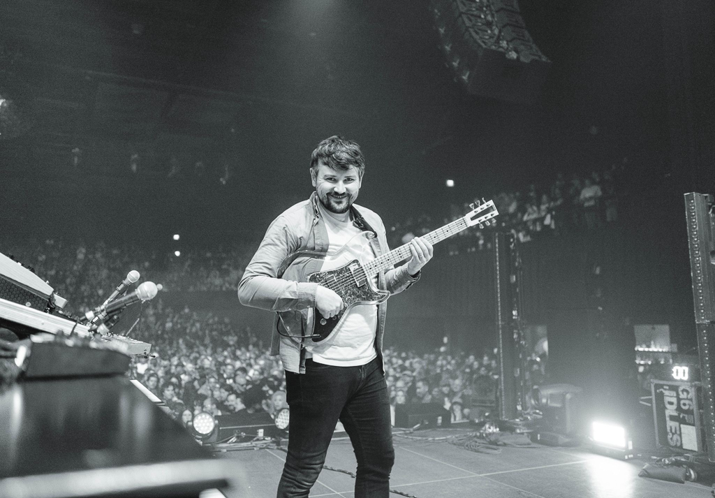 Gavin Maxwell, guitar tech for IDLES and Mogwai, holding IDLES guitarist Mark Bowen's EGC Acrylic guitar