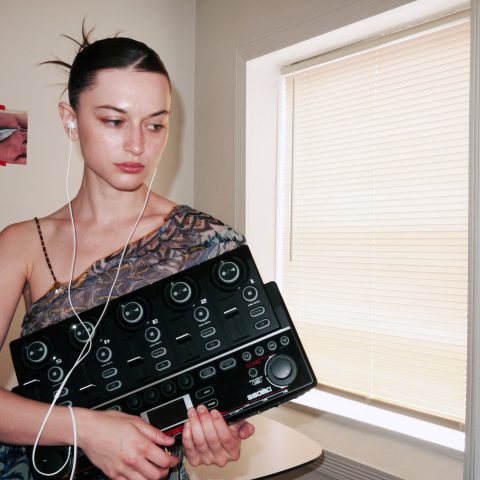 Oxis holding her BOSS RC-505mkII Loop Station