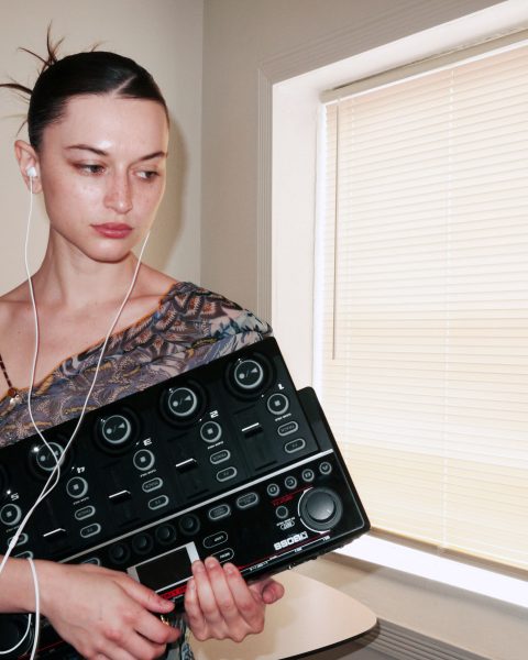 Oxis holding her BOSS RC-505mkII Loop Station
